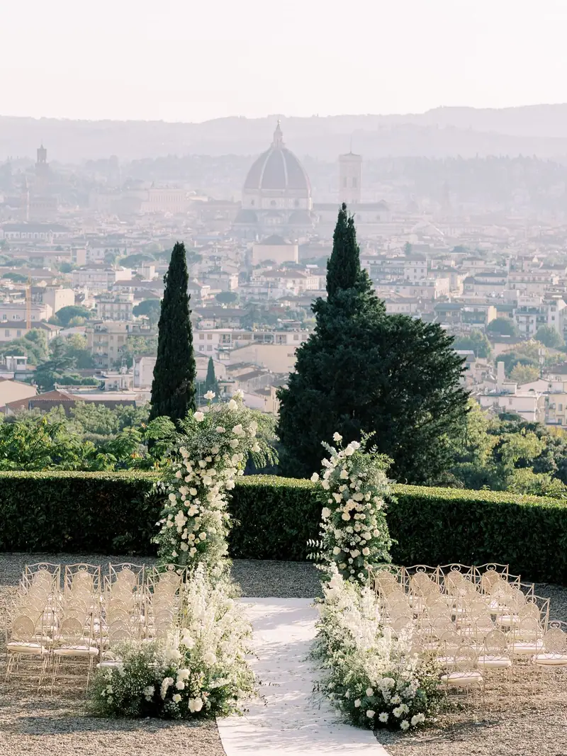L'arco di fiori bianchi e le sedie, con la cupola del Duomo davanti