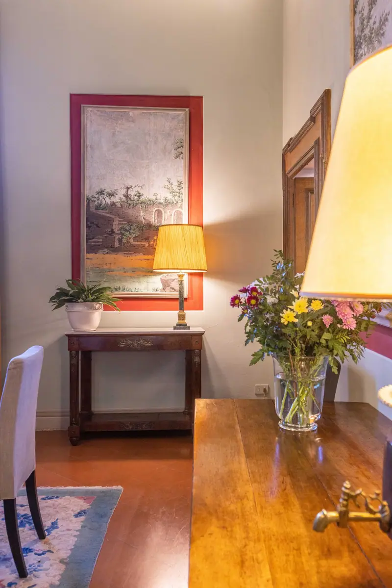 Il salotto con la lampada e i fiori freschi sulla consolle
