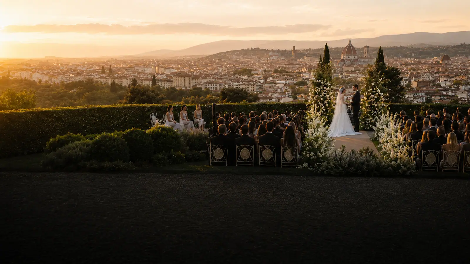 La cerimonia nel giardino della villa: gli sposi all'arco di fiori, gli invitati seduti e tutta Firenze col Duomo sullo sfondo